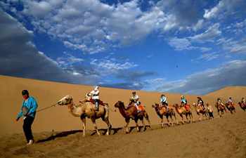 Tourists visit Mingsha Mountain and Crescent Spring scenic spot in Dunhuang, NW China