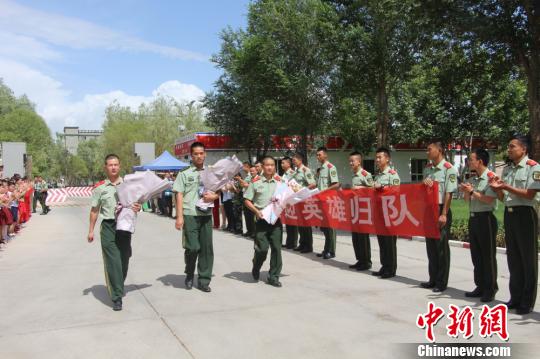 部隊官兵們迎接出院歸來的李運飛(中)和其他消防戰(zhàn)士。　汪渝 攝